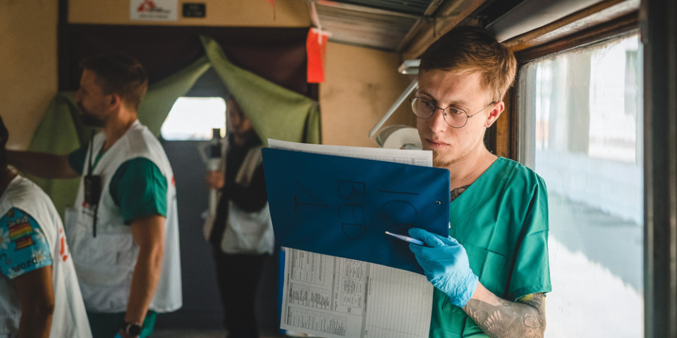 一名無國界醫生護理師正在紀錄醫療列車上加護病房內一名病患的狀況。