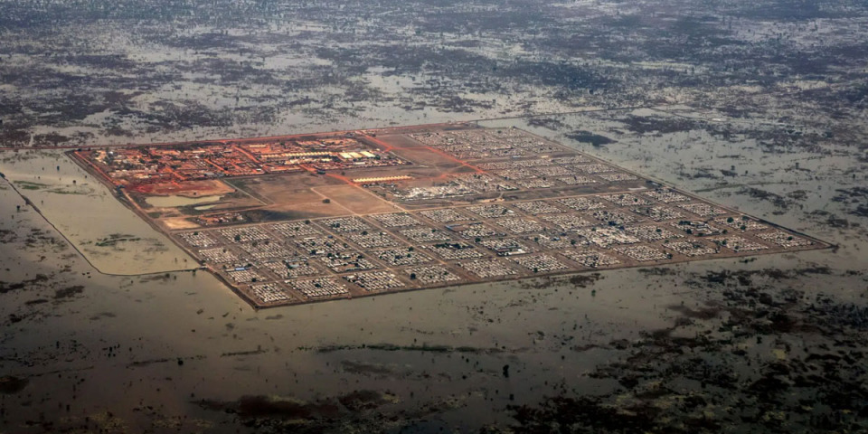 班提烏的流離失所者營地空拍照片，居住了12萬人的營地被洪水圍繞，土堤是營地僅有的防護。攝於南蘇丹，2022年4月。 © PETER CATON