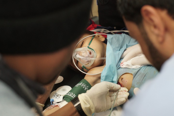 在塔勒艾卜耶德醫院，無國界醫生隊伍正在搶救一名胸口被流彈擊中的敘利亞男孩。©Eddy Van Wessel