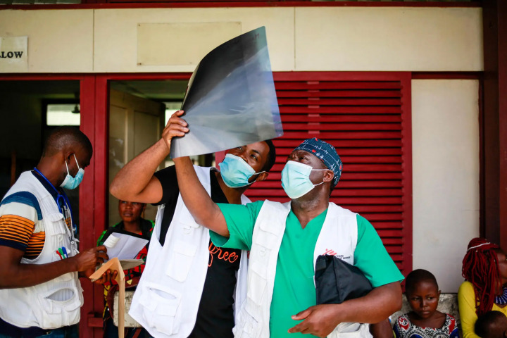 2021年6月，在喀麥隆西南部的馬姆費醫院，兩位MSF醫生正就著光看X光片。© SCOTT HAMILTON/MSF