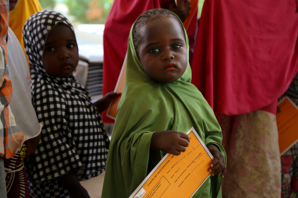 小女孩手持無國界醫生疫苗接種卡 © Igor Barbero/MSF